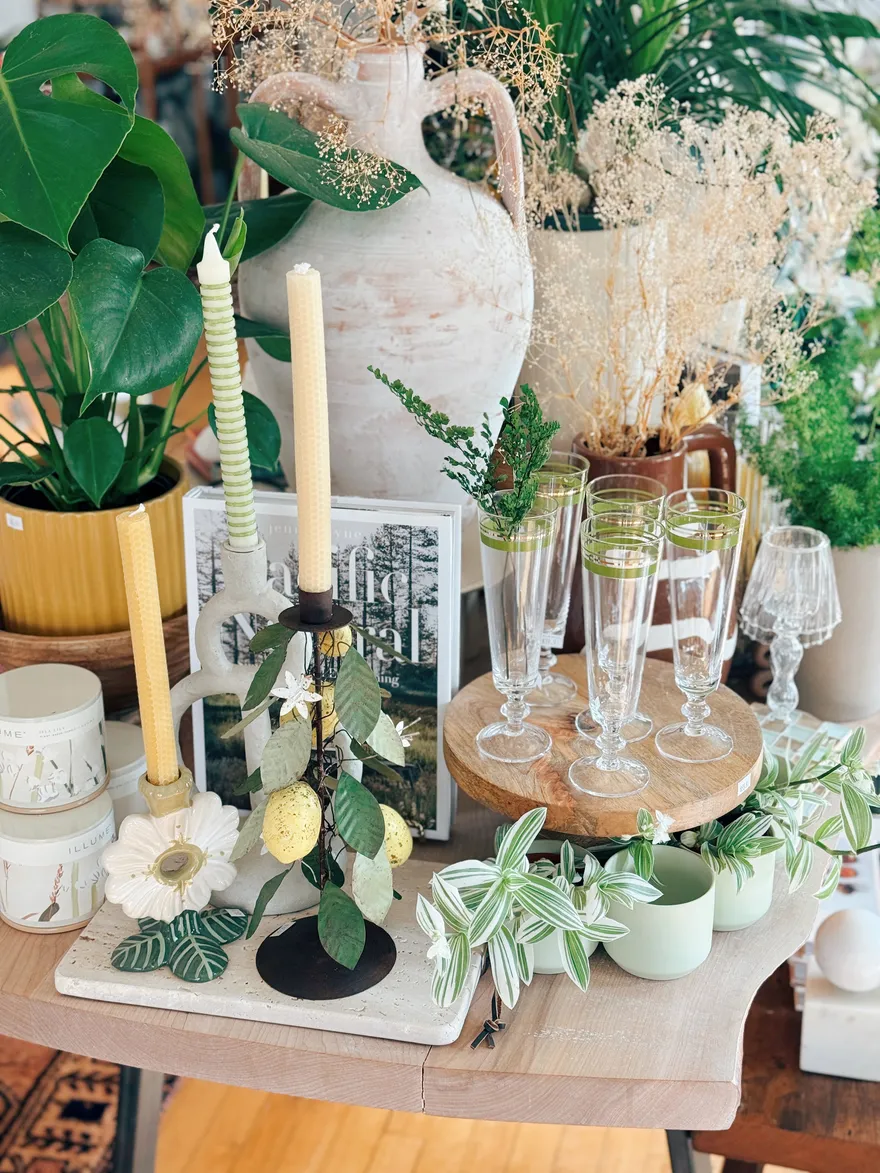 Whitewash amphora with dried florals, a ceramic flower dish and beeswax tapers on a wood stand.