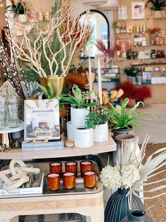 Coffee-table travel books beside amber candles and marble planters.